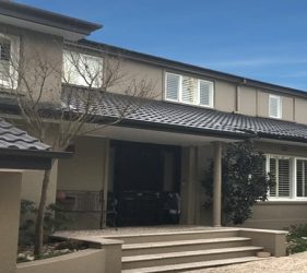 Completed Castle Cove home repaint featuring Monument roof, Dulux Gnu Tan walls, and crisp white window trims