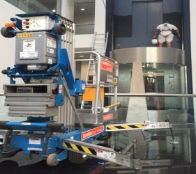 Painter using a one-man lift to repaint a lift shaft overnight in a Northbridge commercial building
