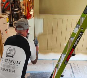 Painting Process – Painter at work with spray equipment during renovation.