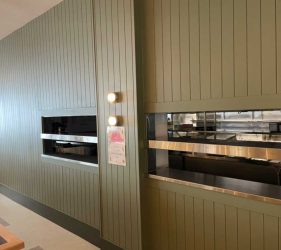 Bar Close-up – Bar counter with green paneling and timber trim details.