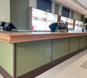 Bar Close-up – Bar counter with green paneling and timber trim details.