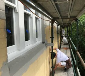 Painting in Progress – Skilled painters restoring the building’s exterior.