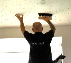 Installer working on retro wallpaper ceiling in Upper North Shore home