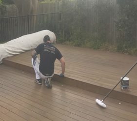 Preparing the deck in Sydney by sanding before applying stain.