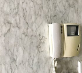 Detail of marble-effect wallpaper and smart panel in Bondi home