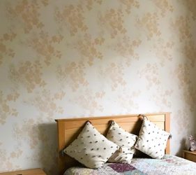 Finished floral wallpaper wall behind bed in Rose Bay
