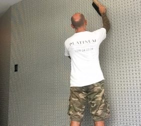 Installer working on geometric black and white feature wall in Vaucluse