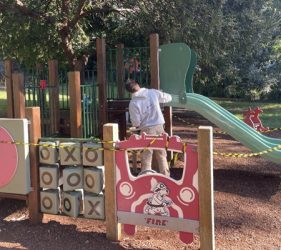 Children’s playground slides and play structures at Lyne Park during the staining process