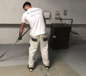 Platinum Painting team applying non-slip epoxy floor coating at a North Sydney strata property for improved safety and durability
