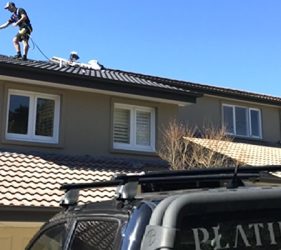 Roof painting in progress with spray application on a tiled roof in Sydney