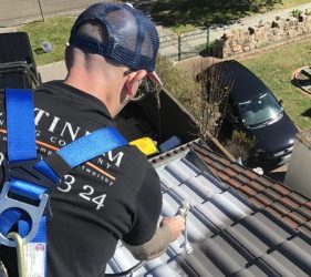 Close-up of roof painting with the top coat being applied by spray gun in Sydney.