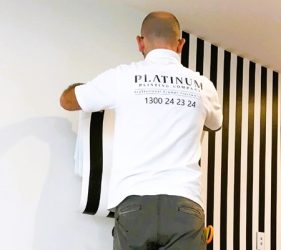 Worker measuring for stripe wallpaper in Bellevue Hill