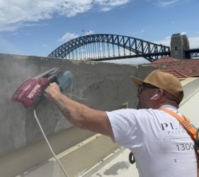 Close-up painter sanding using boom lift in Kirribilli