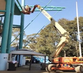 Painter on aerial platform reaching 20m at stadium