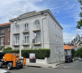 Exterior painting setup with boom lift at Kirribilli strata site