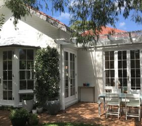 Renovated rear courtyard of Mosman federation home with fresh white exterior and outdoor dining area