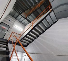 Freshly painted office fire stairwell in Crows Nest with Lexicon white walls, black metal stairs, and vibrant orange handrail