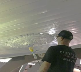 Painter spraying church ceiling during Surry Hills office conversion project